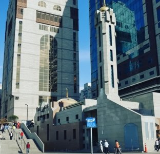 A modern mosque with a sleek minaret located near luxury hotels, part of our premium 4 star Umrah packages for 2026.